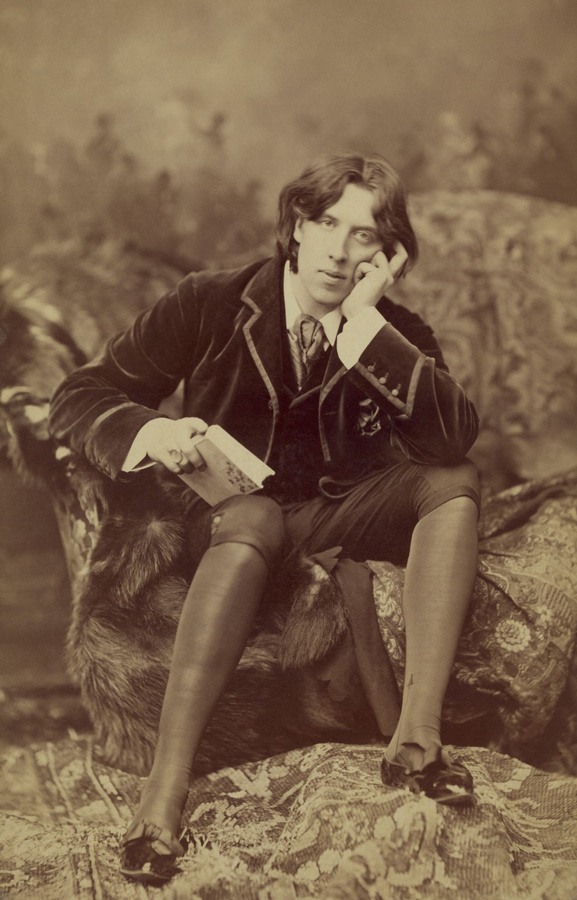 Oscar Wilde, Anglo-Irish playwright and poet in studio portrait by Napoleon Sarony, 1882. Wilde is wearing knee britches, silk stockings, bowed patent leather slippers with a velvet jacket  (BSLOC_2016_11_183)